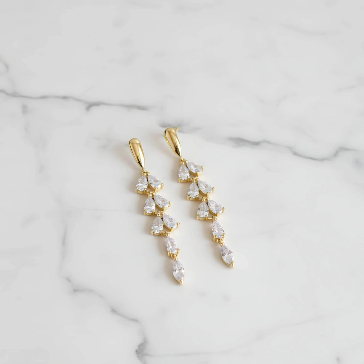 Brincos Zynelle Folhas com Zircônia Brilhante e Franja na Cor Dourada