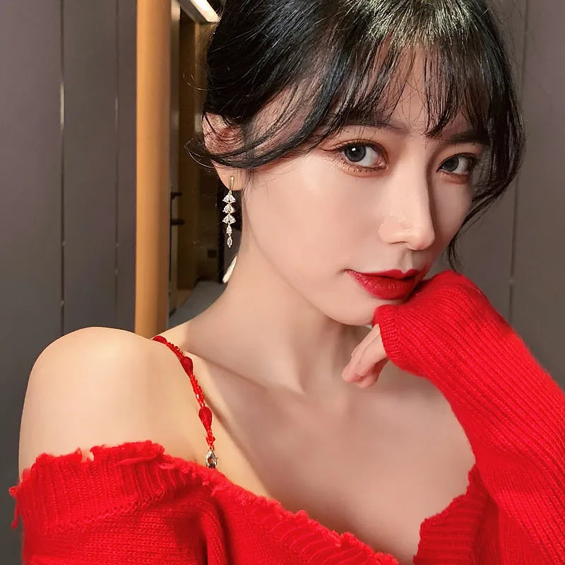 Brincos Zynelle Folhas com Zircônia Brilhante e Franja na Cor Dourada